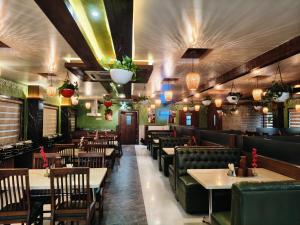a restaurant with tables and chairs and lights at Holiday Residency Coimbatore in Coimbatore