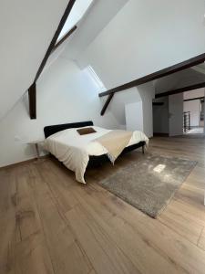 a bedroom with a large bed and a wooden floor at Maison cosy - salle de jeux, cinéma et jacuzzi in Ittenheim