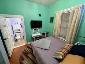 a small bedroom with a bed and a television at Room at 4114 in Seattle