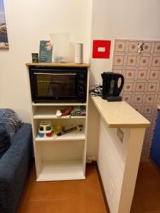 een magnetron op een plank in een kamer bij Bibione Landora Nummer 141 in Bibione