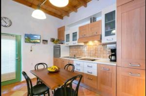 a kitchen with wooden cabinets and a table and chairs at Tolles Ferienhaus In Piskokefalo Mit Terrasse in Piskokéfalon
