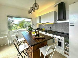 a kitchen with a counter with chairs and a table at Panoramic Villa In The Lucca Hills in Capannori