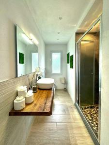 a bathroom with a white tub and a sink at Panoramic Villa In The Lucca Hills in Capannori