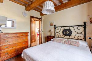 a bedroom with a white bed and a wooden dresser at Historic Village With Pool Near Todi in Todi