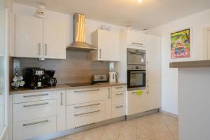 a kitchen with white cabinets and a stove top oven at Seaside Villa With Panoramic Views In Les Îles D'or in La Londe-les-Maures