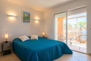a bedroom with a blue bed and a balcony at Seaside Villa With Panoramic Views In Les Îles D'or in La Londe-les-Maures +32 photos