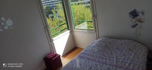 a bedroom with a bed and a large window at Entre Ville & Nature-Sejour idéal a Massy in Massy
