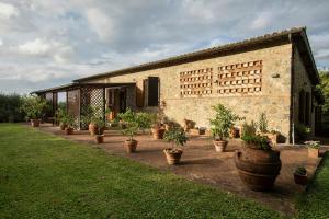 a brick building with potted plants in front of it at Historic Villa With Pool In The Heart Of Chianti in Monteriggioni