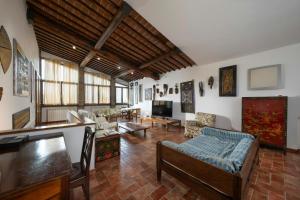 a living room with a couch and a tv at Historic Villa With Pool In The Heart Of Chianti in Monteriggioni