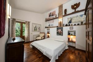 a bedroom with a bed and a desk and a window at Historic Villa With Pool In The Heart Of Chianti in Monteriggioni +12 photos