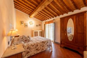 Un dormitorio con una cama y una mesa y una ventana. en Countryside Home With Pool Near Florence, en Castelfiorentino