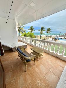 a balcony with a chair and a table and the ocean at Hotel Albemarle Galapagos Beachfront in Puerto Villamil +106 photos