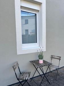 two chairs and a table in front of a window at Ferienwohnung Vino 1881 in Schweich
