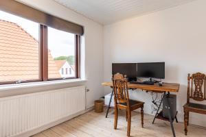a room with a desk with a computer and a window at MuremesterVilla ved Hav og Skov in Stubbekøbing