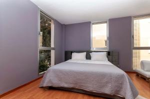 Un dormitorio con una cama grande y dos ventanas. en Modern 3rd floor loft in Alicante, en Alicante