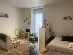 a bedroom with a bed and a couch and a chair at Le Studio d'en O, au coeur de la ville haute in Pornic