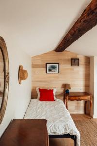 ein Schlafzimmer mit einem roten Kissen auf dem Bett in der Unterkunft Charming House In An Organic Wine Estate in Frontignan