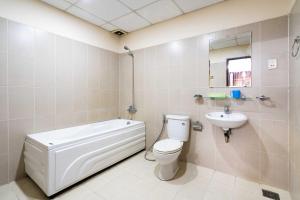 a bathroom with a tub and a toilet and a sink at Dancenter Phuong Nam Hospital Formerly Nam Phuong Hoang Hau in Ho Chi Minh City +21 photos