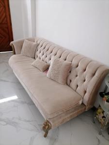 a beige couch sitting in a living room at Charming Home in Negombo