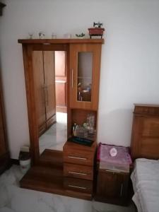 a room with a wooden cabinet and a bed at Charming Home in Negombo