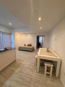 a room with a table and a bed in the background at Urbanstay in Villa Constitución