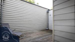 a patio with a chair next to a wall at La terrasse, proche des places 2 chambres in Arras