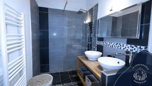 a black and white bathroom with a sink and a mirror at La terrasse, proche des places 2 chambres in Arras +15 photos