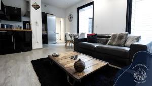 a living room with a couch and a coffee table at La terrasse, proche des places 2 chambres in Arras