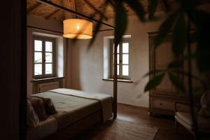 a bedroom with a bed and two windows at Restored Farmhouse In Tuscan Casentino Hills in Poppi