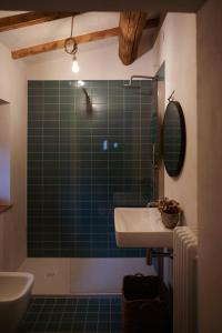 a bathroom with a sink and a green tiled shower at Restored Farmhouse In Tuscan Casentino Hills in Poppi +28 photos