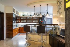 a kitchen with a bar with two bar stools at Tokyo Luxury apartment in Odesa