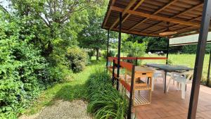 un patio con una mesa y una mesa y un banco en Gîte La Salamandre au Sud de Sarlat, en Groléjac