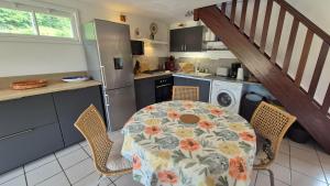 cocina con mesa y mantel con flores en Gîte La Salamandre au Sud de Sarlat, en Groléjac