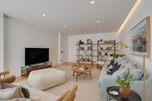 un soggiorno con un divano blu e una TV di Cascais Contemporary Villa by Cadenzalux a Cascais