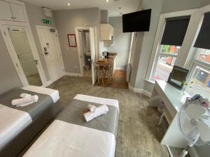 a living room with two beds and a desk and a table at 8 Aspland Road in Norwich