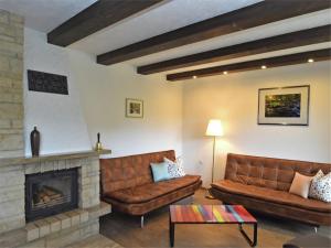 a living room with leather couches and a fireplace at Gruppen- Ferienhaus in Wieda in Wieda +32 photos
