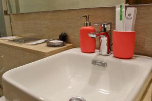 Un lavabo de baño con un cepillo de dientes y un extintor encima. en Maxxvalue Apartment Hiranandani Powai - RH5, en Bombay 19 fotos más