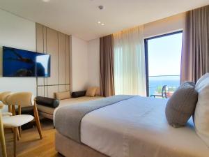 a hotel room with a bed and a large window at Rêve Studio Apartments in Sarandë