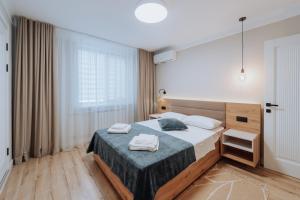 a bedroom with a bed with two towels on it at City Center 2BR with Sauna, Walkable spot in Chişinău