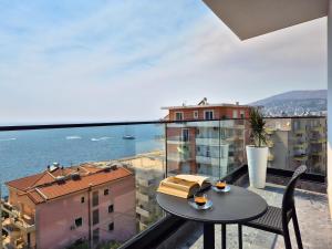 a table and chairs on a balcony with a view of the water at Rêve Studio Apartments in Sarandë