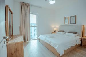 Un dormitorio blanco con una cama y una ventana grande. en Modern 1BR with Lake View Yas Island Stay for 4, en Abu Dabi