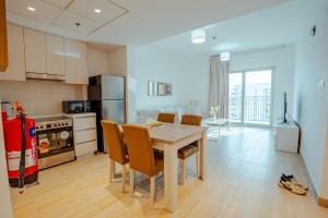 Una cocina y un comedor con mesa y sillas. en Modern 1BR with Lake View Yas Island Stay for 4, en Abu Dabi