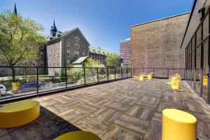 a balcony with yellow tables and chairs on a building at Appartements Dorchester in Montreal