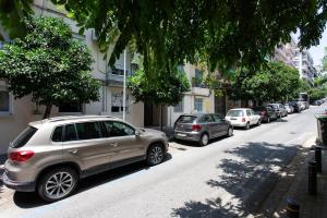 una fila de autos estacionados al lado de una calle en Minimal Apt in the Heart of the city, en Tesalónica