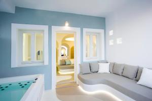 un soggiorno con un divano e un tavolo di Andronikos Santorini a Imerovigli Altre 37 foto