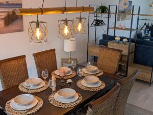 a dining room table with chairs and a blue couch at Ferienlodge Ankerglück in Cuxhaven