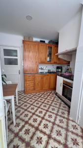 a kitchen with wooden cabinets and a table and a floor at airport room in Lisbon