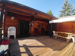a deck of a cabin with a table and chairs at Chalet le TI-KER BREIZH Camping La Buidonnière Aussois in Aussois +6 photos
