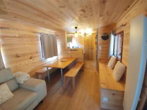 a room with a couch and a table in a tiny house at Chalet le TI-KER BREIZH Camping La Buidonnière Aussois in Aussois