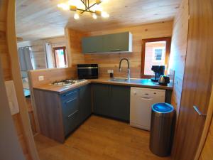 a kitchen with a stove and a sink in a cabin at Chalet le TI-KER BREIZH Camping La Buidonnière Aussois in Aussois